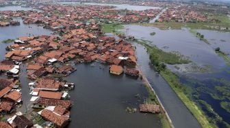 Foto udara limpasan air sungai menuju rumah warga di Pekalongan, Jawa Tengah, Kamis (4/2/2021).  ANTARA FOTO/Harviyan Perdana Putra
