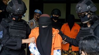 Tim gabungan Detasemen Khusus (Densus) 88 Antiteror Mabes Polri dan Brimob Polda Sulsel menggiring tersangka teroris saat akan diberangkatkan ke Jakarta di Bandara lama Sultan Hasanuddin, Kabupaten Maros, Sulawesi Selatan, Kamis (4/2/2021). ANTARA FOTO/Abriawan Abhe