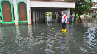 Petugas Balai Kesehatan Masyarakat (Balkesmas) melihat kondisi jalan yang terendam air bercampur limbah di wilayah terdampak banjir di Dusun Tanggulangin, Jati Wetan, Jati, Kudus, Jawa Tengah, Kamis (4/2/2021). ANTARA FOTO/Yusuf Nugroho