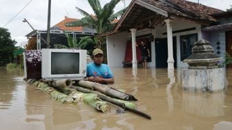 Warga mengevakuasi peralatan elektronik saat banjir menggenangi Dusun Manisrenggo, Desa Gondangmanis, Kecamatan Bandar Kedungmulyo, Kabupaten Jombang, Jawa Timur, Jumat (5/2/2021). ANTARA FOTO/Syaiful Arif