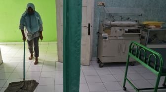 Pekerja membersihkan lantai rumah sakit khusus ibu bersalin positif COVID-19 di Klinik Permata Bhakti, Moyudan, Sleman, D.I Yogyakarta, Jumat (5/2/2021).   [ANTARA FOTO/Andreas Fitri Atmoko