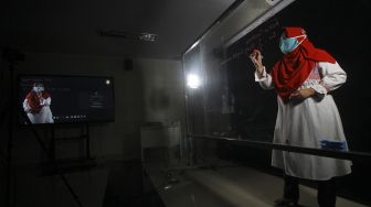 Dosen Universitas Nahdlatul Ulama Surabaya (Unusa) menjelaskan materi pembelajaran memanfaatkan papan kaca (light board) di laboratorium "Microteaching" saat peresmian Laboratorium Virtual Reality dan Microteaching di Universitas Nahdlatul Ulama Surabaya (Unusa), Jawa Timur, Jumat (5/2/2021). [ANTARA FOTO/Moch Asim]