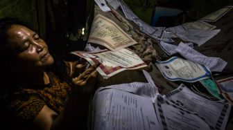 Seorang warga mengeringkan sejumlah dokumen berharga milik keluarganya yang basah terendam banjir di Kelurahan Tanjung Mas, Semarang, Jawa Tengah, Sabtu (6/2/2021). ANTARA FOTO/Aji Styawan