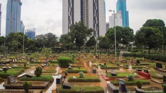 Suasana di area pemakaman yang terendam banjir di TPU Karet Bivak, Jakarta Pusat, Minggu (7/2/2021). [Suara.com/Alfian Winanto]