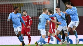 Gelandang Manchester City Phil Foden (tengah) dikelilingi oleh rekan-rekan setimnya setelah dia mencetak gol keempat mereka selama selama pertandingan sepak bola Liga Premier Inggris antara Liverpool melawan Manchester City di Stadion Anfield, Liverpool, Inggris, Senin (8/2/2021) dini hari WIB.
Laurence Griffiths / POOL / AFP