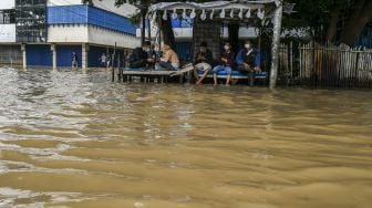 Warga terjebak banjir di Jalan Jatinegara Barat, Kampung Pulo, Jakarta, Senin (8/2/2021). [ANTARA FOTO]
