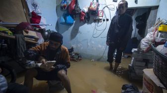 Warga berada di dalam rumahnya yang tergenang air banjir di Pejaten Timur, Pasar Minggu, Jakarta, Minggu (7/2/2021). [ANTARA FOTO]