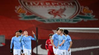 Gelandang Manchester City Phil Foden (kiri) merayakan gol keempat mereka selama pertandingan sepak bola Liga Premier Inggris antara Liverpool melawan Manchester City di Stadion Anfield, Liverpool, Inggris, Senin (8/2/2021) dini hari WIB. Laurence Griffiths / POOL / AFP
