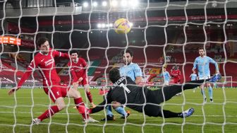 Kiper Liverpool Alisson Becker mencoba menahan tendangan dari gelandang Manchester City Ilkay Gundogan selama pertandingan sepak bola Liga Inggris antara Liverpool melawan Manchester City stadion Anfield, Liverpool, Inggris, Senin (8/2/2021) dini hari WIB.
Laurence Griffiths / POOL / AFP

