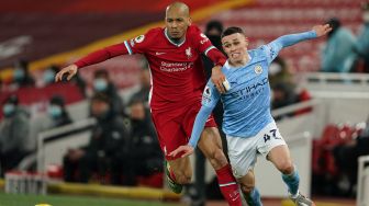 Gelandang Liverpool Fabinho (kiri) bersaing dengan gelandang Manchester City Phil Foden (kanan) selama pertandingan sepak bola Liga Premier Inggris antara Liverpool melawan Manchester City di Stadion Anfield, Liverpool, Inggris, Senin (8/2/2021) dini hari WIB. Jon Super / POOL / AFP
