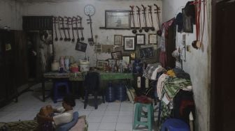 Warga beraktivitas di rumah industri kecil pembuat alat musik Tehyan Mpe Goyong yang berada di lingkugan Kampung Tehyan, Kota Tangerang, Banten, Selasa (9/2/2021). [Suara.com/Angga Budhiyanto]