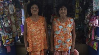 Warga Kampung Tehyan, Una (69) dan Uni (69) berpose di sela-sela beraktivitas di Kampung Tehyan, Kota Tangerang, Banten, Selasa (9/2/2021). [Suara.com/Angga Budhiyanto]