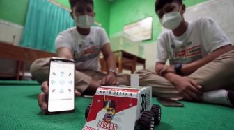 Tim robotik Laskar Bumi Bung Karno menjelaskan kinerja robot buatannya di ruang robotik Madrasah Tsanawiyah Negeri (MTsN) Kepanjen Kidul Blitar, Jawa Timur, Selasa (9/2/2021).  [ANTARA FOTO/Irfan Anshori]