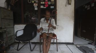 Pembuat alat musik Tehyan, Ghohyong memainkan alat musik buatannya di Kampung Tehyan, Kota Tangerang, Banten, Selasa (9/2/2021). [Suara.com/Angga Budhiyanto]