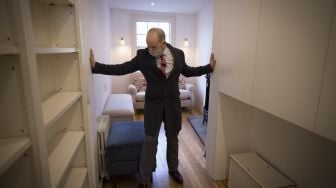 Agen real estate, David Myers memimpin tur ke 'rumah tertipis di London', London Barat, pada (5/2/2021). [Tolga Akmen / AFP]