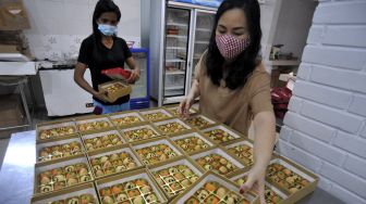 Penjual mengemas kue nastar karakter bertema Imlek di Angie's Cake Denpasar, Bali, Selasa (9/2/2021). [ANTARA FOTO/Fikri Yusuf]