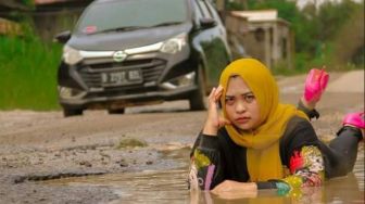 Viral Foto Wanita Berpose Bak Model di Jalan Rusak dan Berlubang