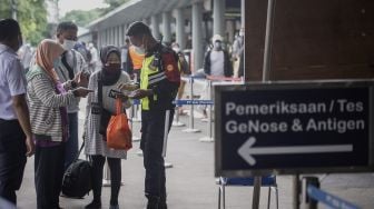 Petugas memeriksa tiket calon penumpang kereta api sebelum mengikuti tes cepat GeNose C19 atau Antigen di Stasiun Pasar Senen, Jakarta, Jumat (12/2/2021). [ANTARA FOTO/Aprillio Akbar]