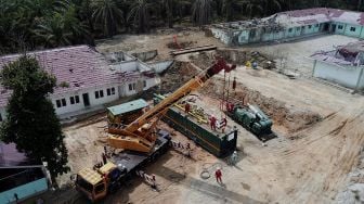 Sejumlah pekerja EMP Bentu mengoperasikan alat berat di tempat semburan gas bercampur lumpur, di Pondok Pesantren Al-Ihsan, Kota Pekanbaru, Riau, Sabtu (13/2/2021). [ANTARA FOTO/FB Anggoro]