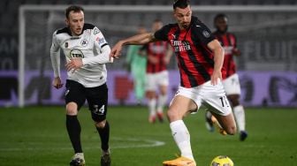 Pemain depan AC Milan Zlatan Ibrahimovic (kanan) melewati bek Spezia Ardian Ismajli  selama pertandingan sepak bola Serie A Italia Spezia melawan AC Milan di Stadion Alberto Picco, Minggu (14/2/2021) dini hari WIB. Marco BERTORELLO / AFP