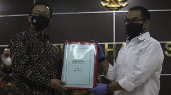 Dirtipidum Bareskrim Polri Brigjen Pol Andi Rian S Djajadi (kanan) menerima barang bukti terkait tewasnya enam laskar FPI dari Komisioner Komnas HAM di Kantor Komnas HAM, Jakarta, Selasa (16/2/2021). [Suara.com/Angga Budhiyanto]
