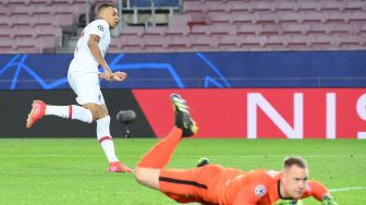 Penyerang Paris Saint-Germain Kylian Mbappe mencetak gol selama pertandingan leg pertama babak 16 besar Liga Champions antara Barcelona melawan Paris Saint-Germain di stadion Camp Nou, Barcelona, Spanyol, Rabu (17/2) dini hari WIB. [LLUIS GENE / AFP]

