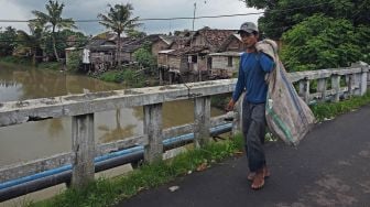 Pemulung melintas di Kampung Ciputri, Kasemen, Serang, Banten, Rabu (17/2/2021). [ANTARA FOTO/Asep Fathulrahman]