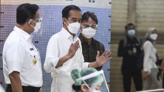 Presiden Joko Widodo (kiri) didampingi Gubernur DKI Jakarta Anies Baswedan (kedua kiri) meninjau vaksinasi COVID-19 massal bagi pedagang di Pasar Tanah Abang Blok A, Jakarta, Rabu (17/2/2021). ANTARA FOTO/Hafidz Mubarak 
