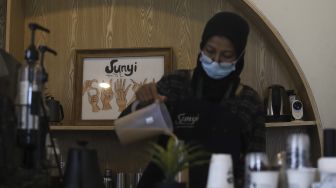 Barista yang seorang tunarungu meracik kopi pesanan pengunjung di Kafe Sunyi, Cilandak, Jakarta Selatan, Kamis (18/2/2021). [Suara.com/Angga Budhiyanto]