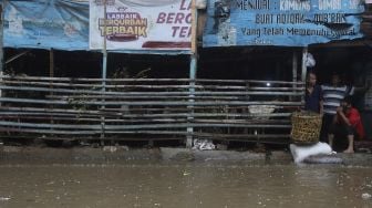 Sejumlah warga berada di salah satu lapak penjual kambing saat banjir merendam kawasan Kemang Utara, Jakarta, Kamis (18/2/2021). [Suara.com/Angga Budhiyanto]