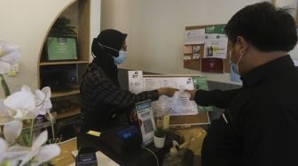 Barista yang seorang tunarungu, dengan menggunakan bahasa isyarat melayani pengunjung di Kafe Sunyi, Cilandak, Jakarta Selatan, Kamis (18/2/2021). [Suara.com/Angga Budhiyanto]