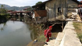 Seorang pelajar berada di kawasan perumahan kumuh yang tidak layak huni di pinggiran Krueng (sungai) Daroy, Aceh Besar, Aceh, Kamis (18/2/2021).  ANTARA FOTO / Irwansyah Putra