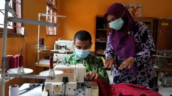 Seorang guru memberikan pelatihan ketrampilan menjahit kepada pelajar di Sekolah Luar Biasa (SLB) Dharma Putra, Semin, Gunung Kidul, D.I Yogyakarta, Jumat (19/02/2021).  ANTARA FOTO/Andreas Fitri Atmoko