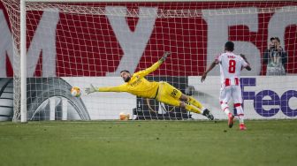 Gelandang Red Star Belgrade, Guelor Kanga Kakou (kanan) melakukan tendangan penalti selama pertandingan sepak bola babak 32 besar Liga Europa antara Red Star Belgrade melawan AC Milan  di Stadion Rajko Mitic, Beograd, Jumat (19/2/2021) dini hari WIB. pedja milosavljevic / AFP
