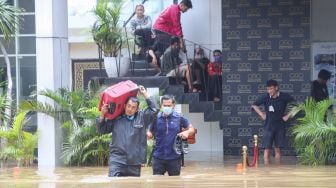 Warga mengungsikan barang - barangnya dari banjir di Kemang, Jakarta Selatan, Sabtu (20/2/2021). [Suara.com/Alfian Winanto]