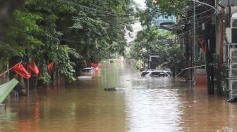 Mobil - mobil terendam banjir di Kemang, Jakarta Selatan, Sabtu (20/2/2021). [Suara.com/Alfian Winanto]