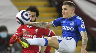 Bek Everton Lucas Digne (kanan) bersaing dengan gelandang Liverpool Mohamed Salah (kiri) selama pertandingan sepak bola Liga Premier Inggris antara Liverpool dan Everton di Stadion Anfield, Liverpool, Inggris, pada (20/2/2021). [Paul ELLIS / POOL / AFP]