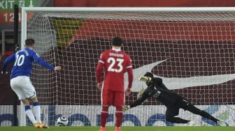 Gelandang Everton Gylfi Sigurdsson (kiri) mencetak gol kedua mereka dari titik penalti selama pertandingan sepak bola Liga Premier Inggris antara Liverpool dan Everton di Stadion Anfield, Liverpool, Inggris, pada (20/2/2021). [Paul ELLIS / POOL / AFP]