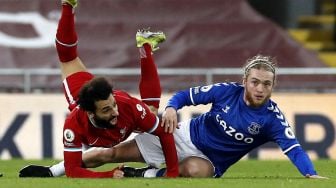 Gelandang Liverpool Mohamed Salah (kiri) bersaing dengan gelandang Everton Tom Davies (kanan) selama pertandingan sepak bola Liga Utama Inggris antara Liverpool dan Everton di Stadion Anfield, Liverpool, Inggris, pada (20/2/2021). [PHIL NOBLE / POOL / AFP]