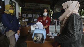 Warga mendaftarkan hewan peliharaannya untuk dilakukan pemeriksaan kesehatan hewan terdampak banjir di Kantor Kelurahan Pela Mampang, Jakarta, Senin (22/2/2021). [Suara.com/Angga Budhiyanto]