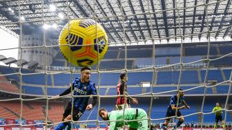 Penyerang Inter Milan Lautaro Martinez melakukan selebrasi setelah mencetak gol keduanya melewati penjaga gawang Italia AC Milan Gianluigi Donnarumma selama pertandingan sepak bola Serie A Italia AC Milan melawan Inter Milan di San Siro, Milan, Italia, Minggu (21/2/2021) malam WIB.  Miguel MEDINA / AFP
