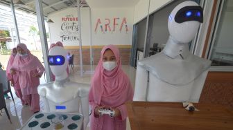 Santri menjalankan robot pelayan kafe menggunakan remote di Kafe Arfa, Perguruan Diniyah Putri Padangpanjang, Sumatera Barat, Senin (22/2/2021). ANTARA FOTO/Iggoy el Fitra
