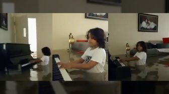 Aksi Anak Main Piano Mesk Setengah Badannya Terendam Banjir