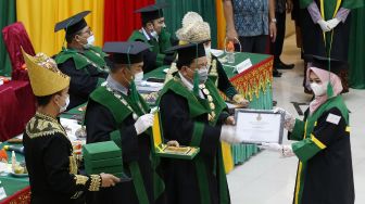 Rektor Universitas Islam Negeri (UIN) Ar-Raniry Prof Warul Walidin (ketiga kiri) menyerahkan piagam penghargaan kepada lulusan terbaik Program Doktor, Pascasarjana dan Sarjana yang diwisuda di Auditorium Prof Ali Hasjmy Kopelma Darussalam, Banda Aceh, Aceh, Selasa (23/2/2021). ANTARA FOTO /Irwansyah Putra