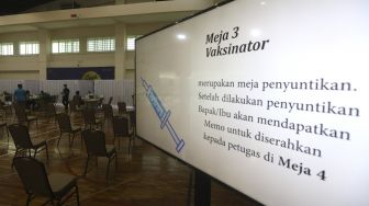 Petugas kesehatan memeriksa kesehatan jurnalis dan pegawai KPK sebelum melakukan vaksinasi COVID-19 di Gedung Penunjang Komisi Pemberantasan Korupsi (KPK), Jakarta, Selasa (23/2/2021). [Suara.com/Angga Budhiyanto]