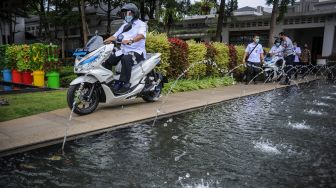 Seorang Aparatur Sipil Negara (ASN) mengendarai motor listrik saat penyerahan motor listrik bagi ASN di Balai Kota Bandung, Jawa Barat, Rabu (24/2/2021). [ANTARA FOTO/Raisan Al Farisi]