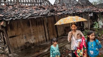 Warga berada di depan rumahnya yang rusak akibat dihantam angin puting beliung di Desa Karangsono, Kecamatan Mranggen, Kabupaten Demak, Jawa Tengah, Rabu (24/2/2021). ANTARA FOTO/Aji Styawan
