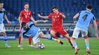 Pemain Bayern Munich Robert Lewandowski menantang bek Lazio Francesco Acerbi selama pertandingan leg pertama babak 16 besar Liga Champions Lazio melawan Bayern Munich di Stadion Olimpico, Roma, Rabu (24/2/2021) dini hari WIB. Alberto PIZZOLI / AFP
