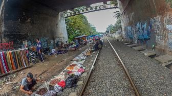 Pedagang menata barang-barang di pasar kaget pinggir rel kawasan Citeureup, Kabupaten Bogor, Jawa Barat, Jumat (26/2/2021). ANTARA FOTO/Yulius Satria Wijaya