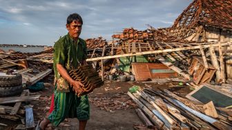 Warga mengumpulkan sisa material dari rumah kerabatnya yang roboh dihantam angin puting beliung, di Desa Sidogemah, Kecamatan Sayung, Kabupaten Demak, Jawa Tengah, Jumat (26/2/2021). ANTARA FOTO/Aji Styawan